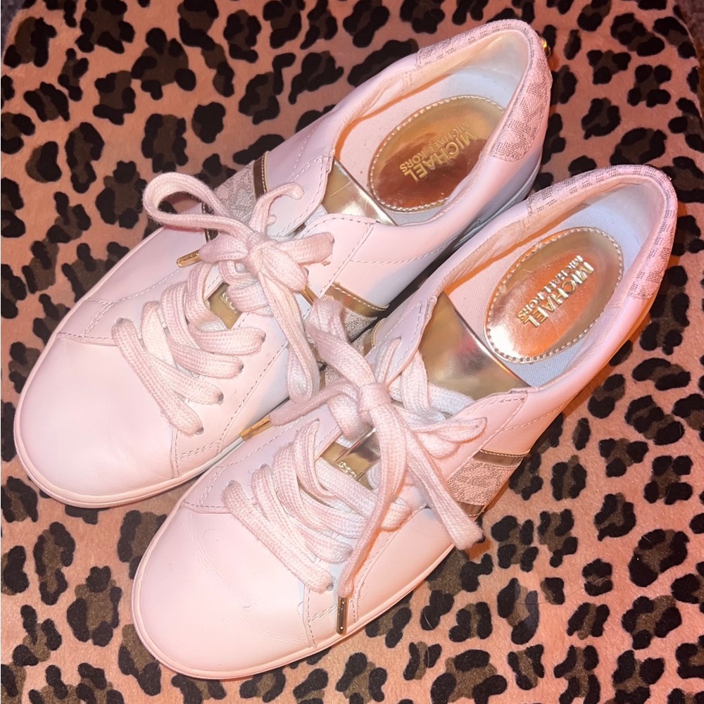 Gold trim and luxe look to sleek leather Micheal Kors sneakers. Lace-up closure.